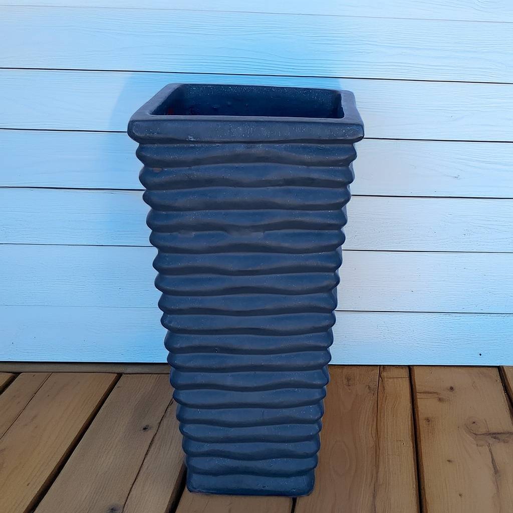 Tall, wavy ceramic planter in matte blue