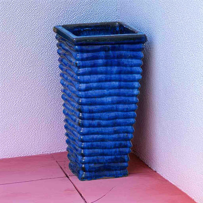 Tall, wavy ceramic planter in blue