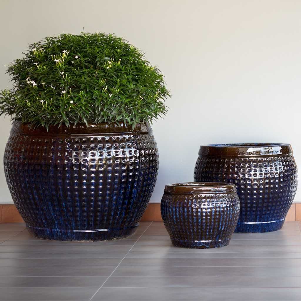 Glazed round ceramic planter pots in blue and brown with a raised grid texture