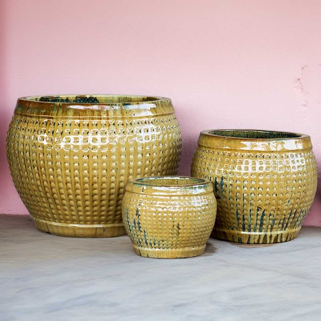 Glazed yellow round ceramic planter pots featuring a raised grid texture