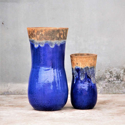 Two ceramic planters in vibrant blue glaze with a rustic, unglazed rim