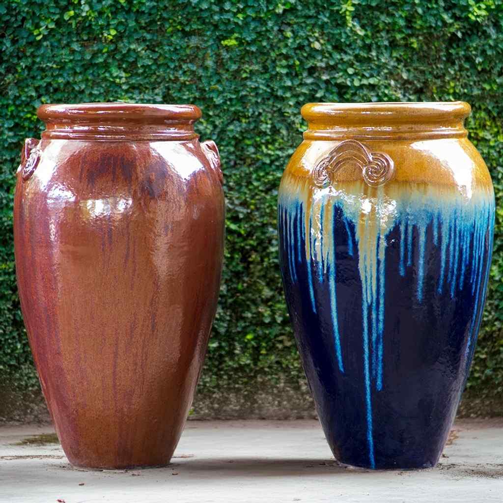 Elegant tall ceramic planters featuring a rustic textured reddish-brown finish and vibrant blue glaze with golden-yellow dripping accents