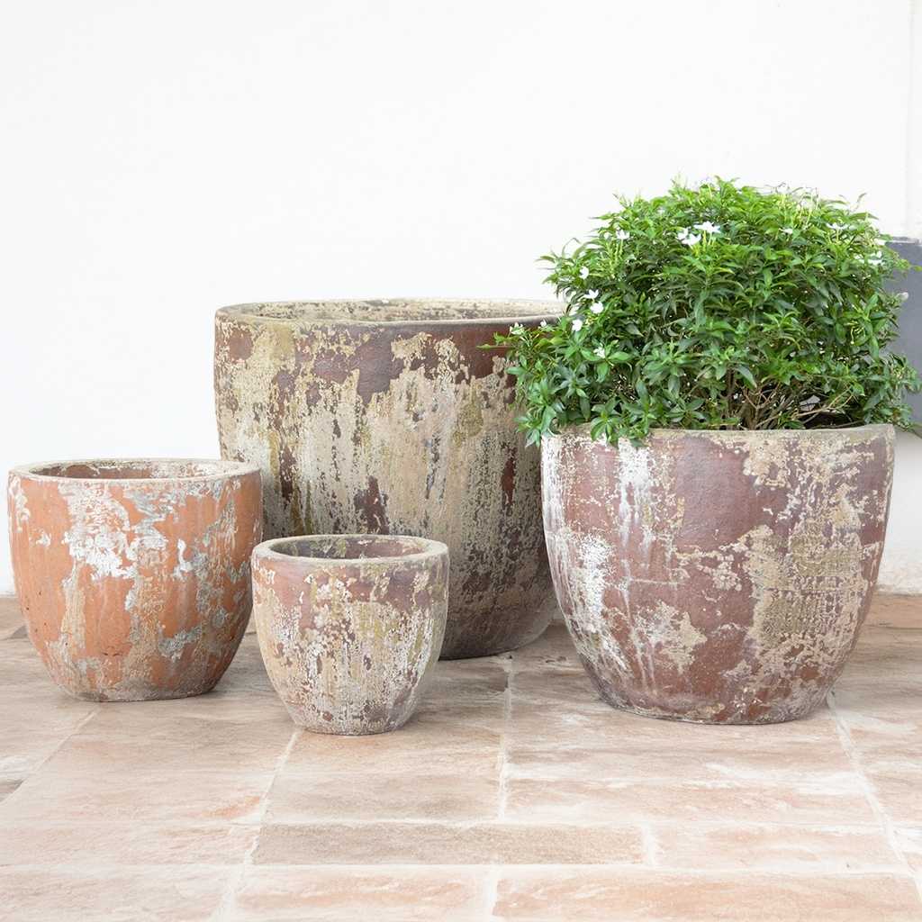 Wholesale Flared square-rimmed ceramic planter in rustic, distressed terracotta glaze, featuring textured grooves and ridges for a weathered, artisanal look