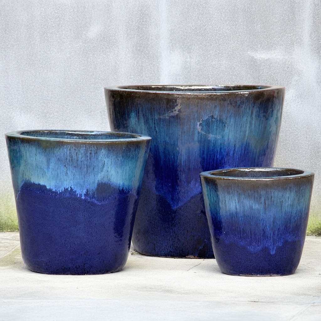 Tapered round ceramic planter in dark blue with a striking dripping glaze