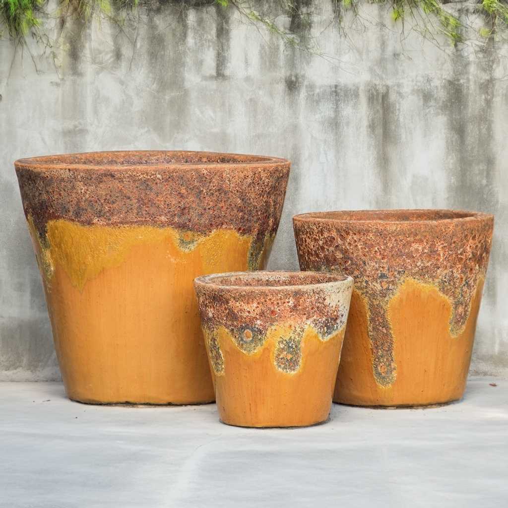 Tapered round ceramic planter in vibrant orange with a textured top rim 