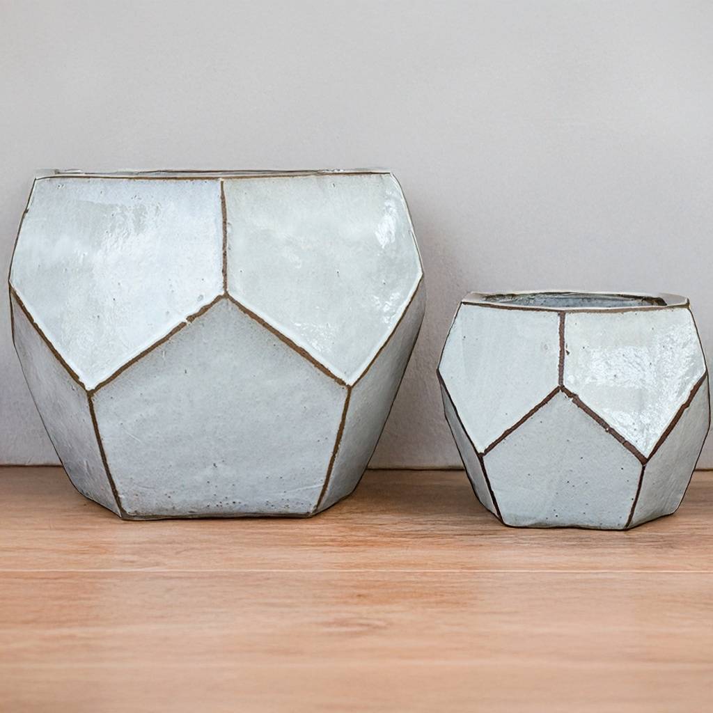 Faceted geometric polygon ceramic planter in white with brown accents, featuring sharp edges and a modern, sculptural design