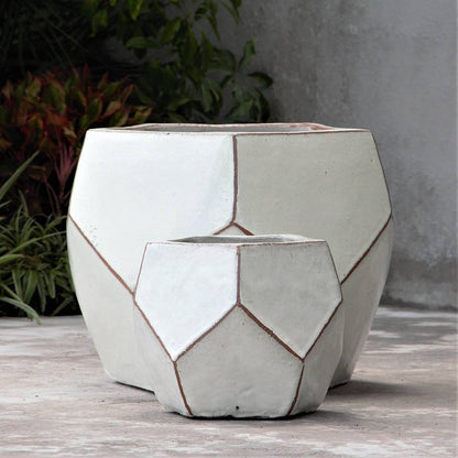 Faceted geometric polygon ceramic planter in white with brown accents, featuring sharp edges and a modern, sculptural design