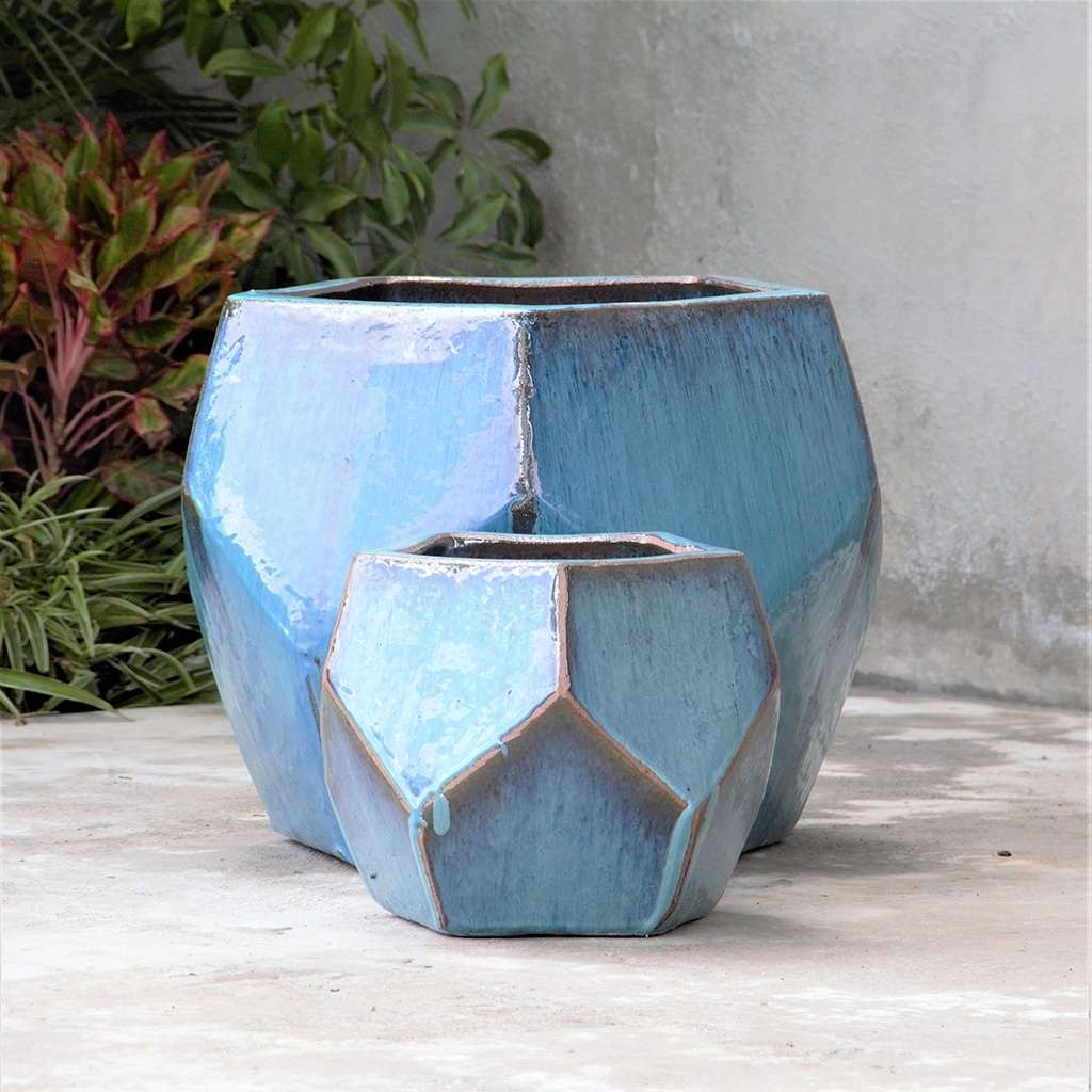 Faceted geometric polygon ceramic planter in turquoise with brown accents, featuring sharp edges and a modern design