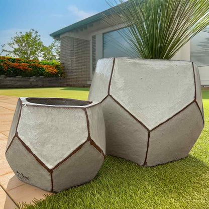 Faceted geometric polygon ceramic planter in cream with brown accent details highlighting its angular design