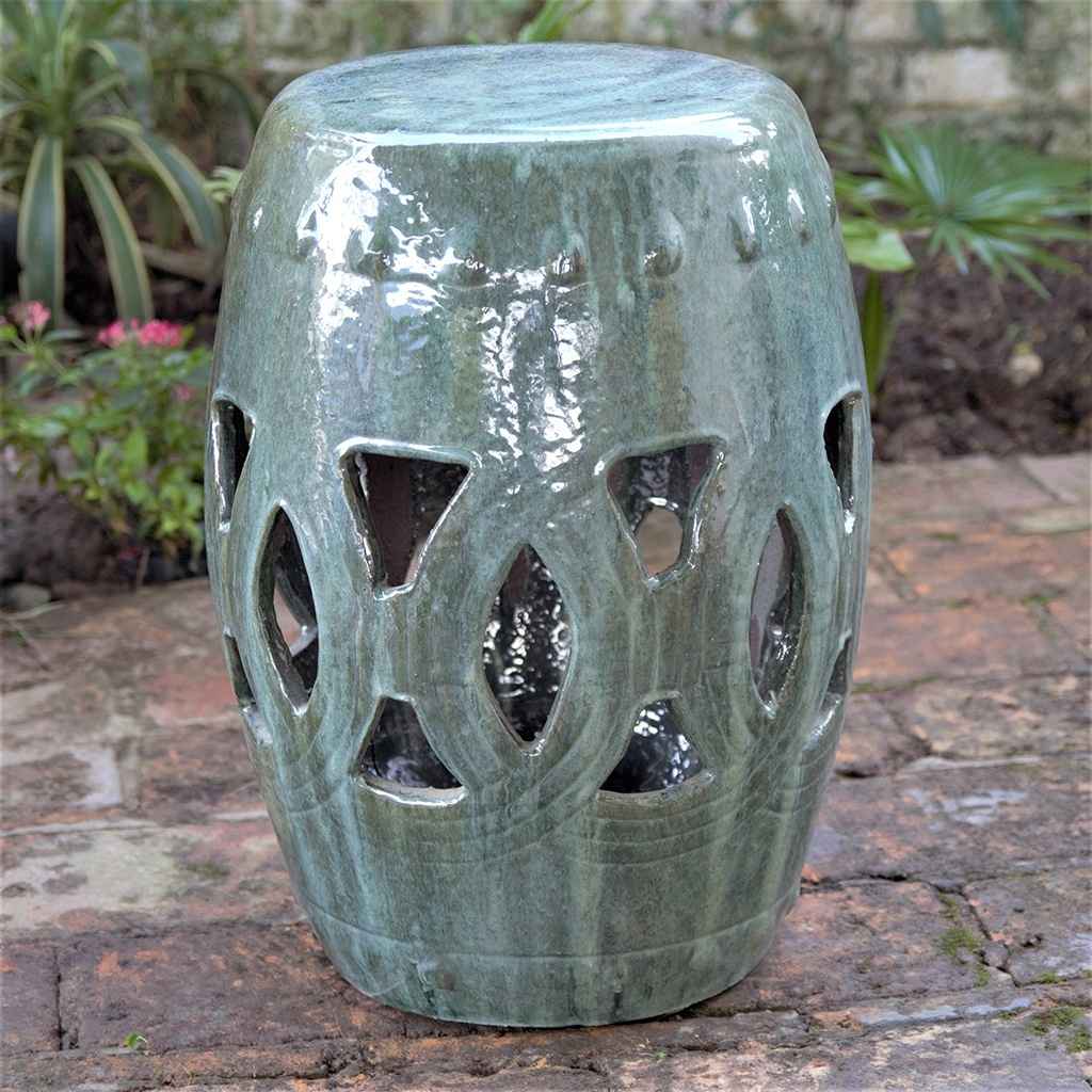 Ceramic garden stool in greenish-blue with a glossy, crackled glaze and decorative cut-out patterns for added texture and charm