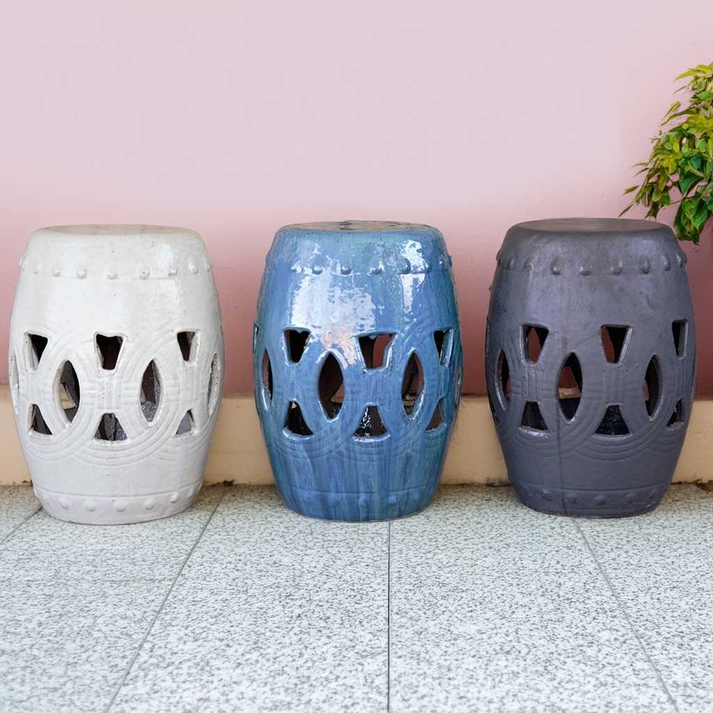 Ceramic garden stools in off-white, blue, and dark gray hues, featuring intricate openwork cutout designs for decorative outdoor seating
