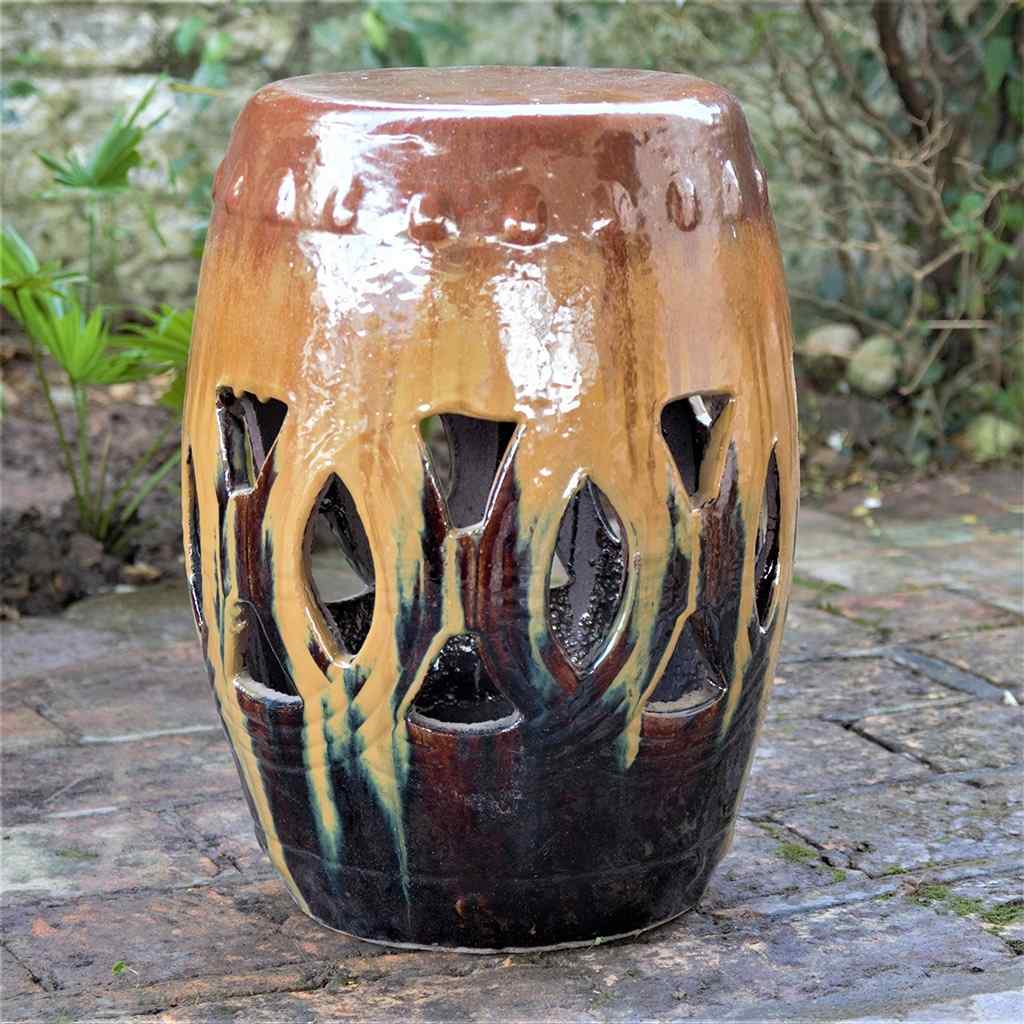 Wholesale Multi-toned ceramic garden stool featuring a unique openwork pattern and a glazed brown finish with an amber, golden-brown flowing effect