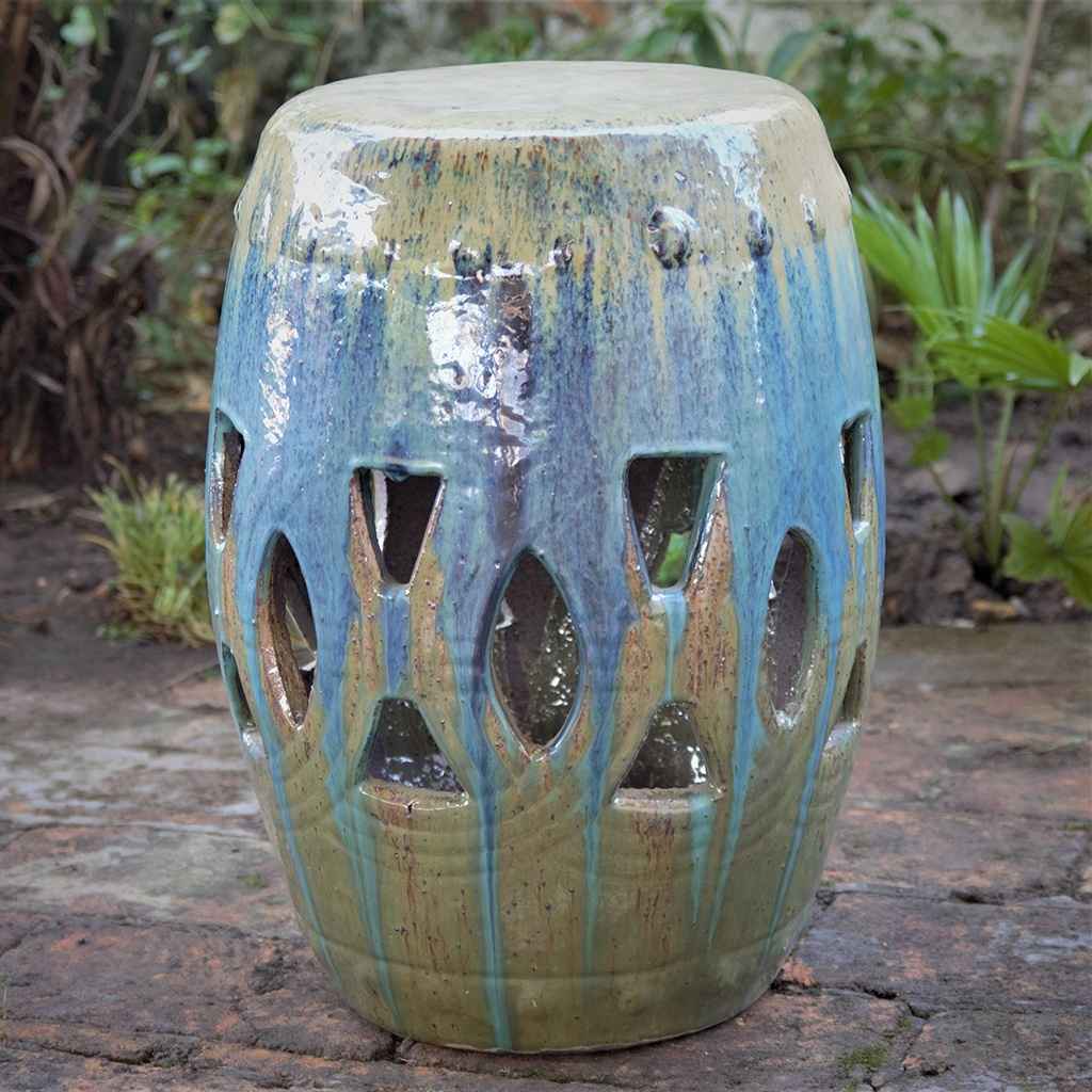 Ceramic garden stool featuring a drip glaze design in blue, green, and brown tones, with decorative cut-out patterns for added texture and charm