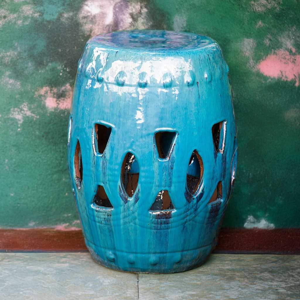 Ceramic garden stool in turquoise with darker striations creating a mottled glaze effect, featuring a decorative cut-out for added visual interest