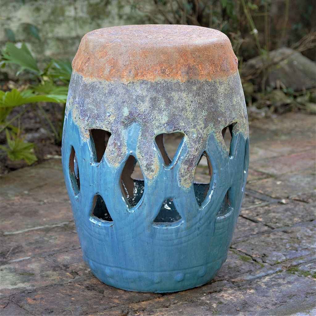 Ceramic garden stool featuring a lattice cut-out pattern in vibrant blue with mottled grey-blue and a distressed top, creating a textured, aged appearance