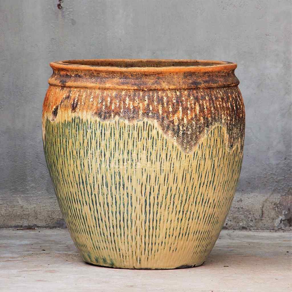 Barrel-shaped ceramic pot in a greenish-beige hue with a rustic, textured top