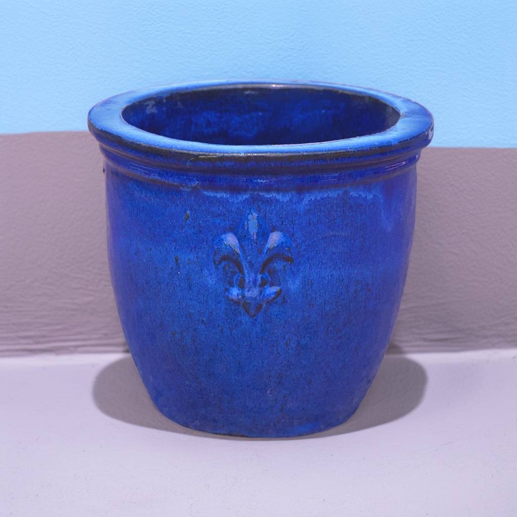 Round ceramic planter featuring elegant fleur-de-lis embossing and a glossy blue finish