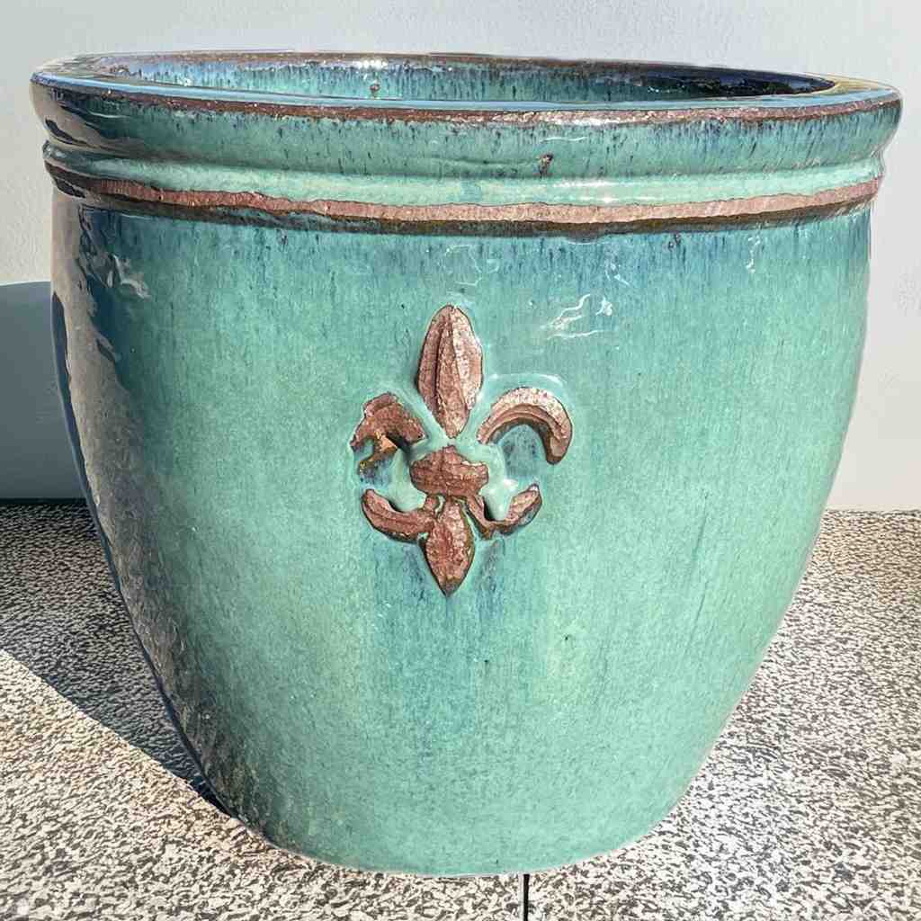 Round ceramic planter featuring elegant fleur-de-lis embossing and a glossy green finish