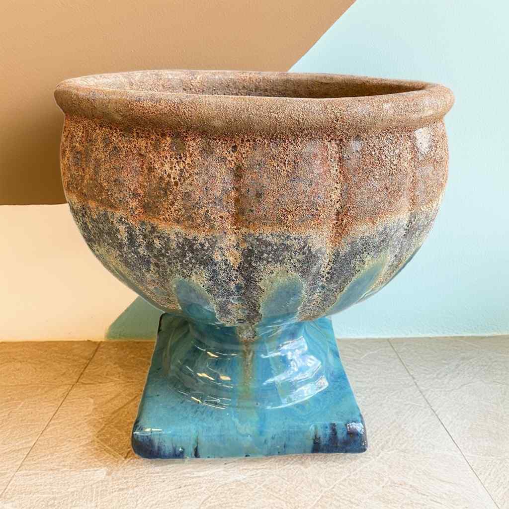 Elegant pedestal pot in glossy greenish-blue glaze with Angkor-style rim in earthy tones for a striking, rustic contrast