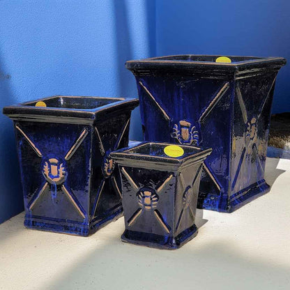 Wholesale set of 3 Glossy blue-black square ceramic planters with a flared rim and embossed regal motif 