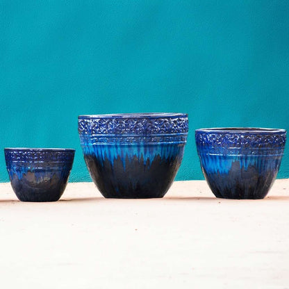 Round ceramic planters with a drip-glazed effect in shades of blue and embossed floral rims