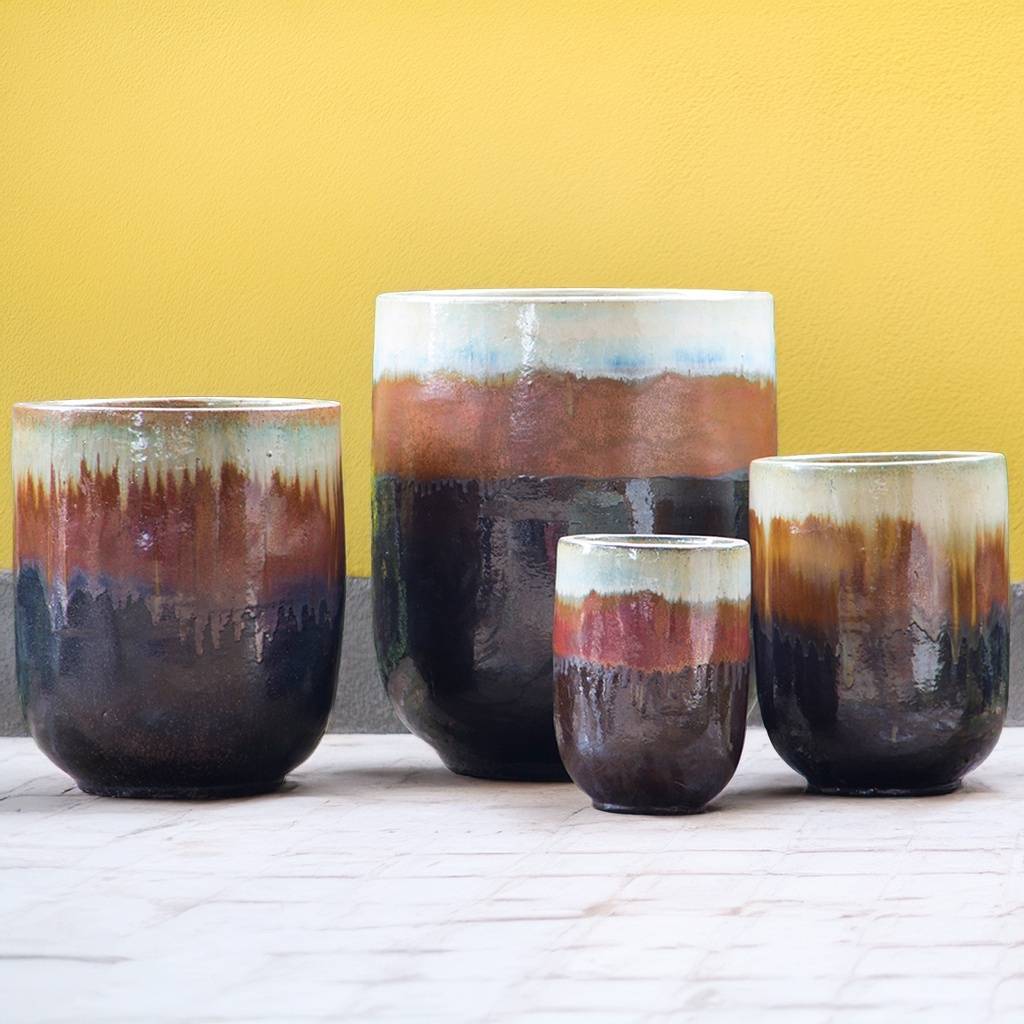 Tall glazed ceramic rounded cylinder planters featuring a drip glaze design with a multicolor palette of browns, tans, blues, and whites blending in overlapping glazes