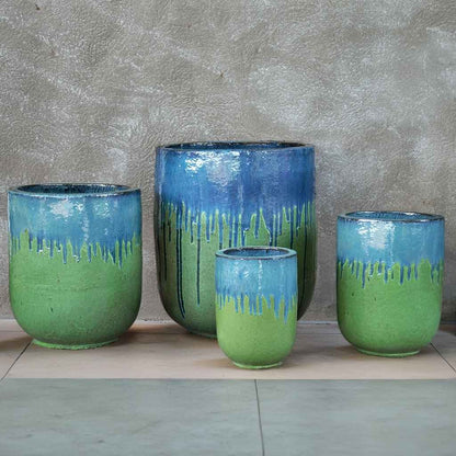 Tall rounded cylinder ceramic planters in glossy green glaze with distinctive blue drip accents