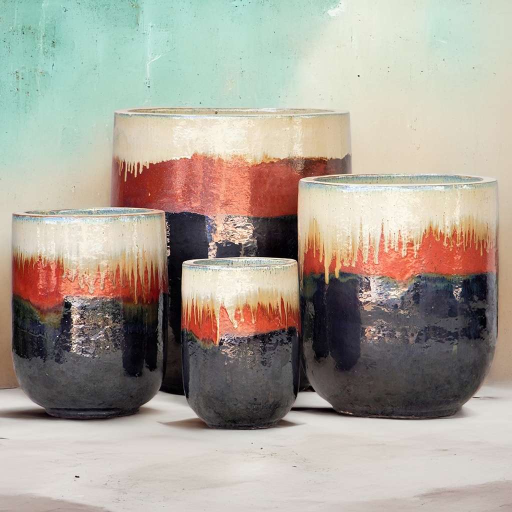 Tall rounded cylinder ceramic planters with a multicolored glaze—blue-gray base, vibrant earthy red-orange middle, and creamy off-white rim