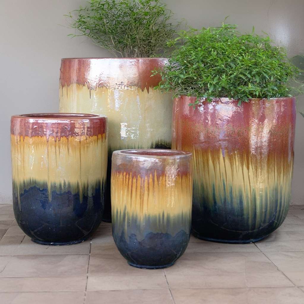Wholesale Tall glazed ceramic rounded cylinder planters with an ombré design transitioning from deep blue at the base to vibrant yellow-gold in the middle and warm reddish-brown at the rim