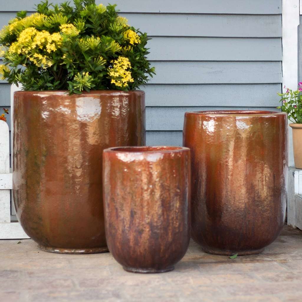 Tall, rounded cylinder planters in volcanic red with a smooth finish