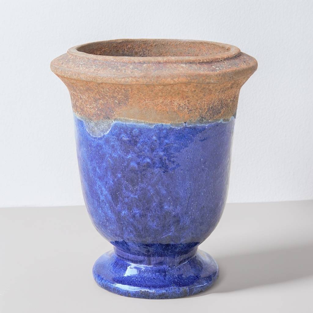 Two-tone pedestal ceramic planter featuring a glossy blue glaze and a textured, unglazed brown rim