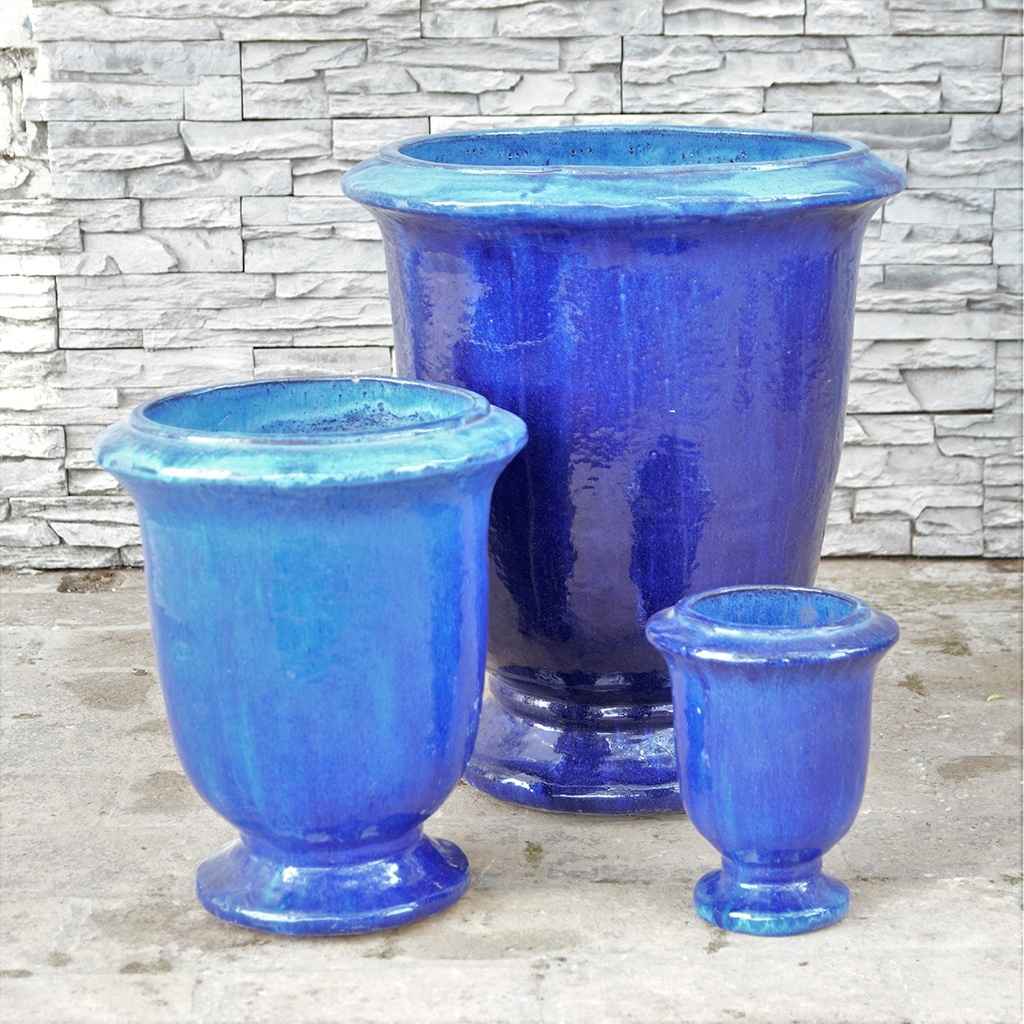 Pedestal ceramic planters featuring a glossy blue finish