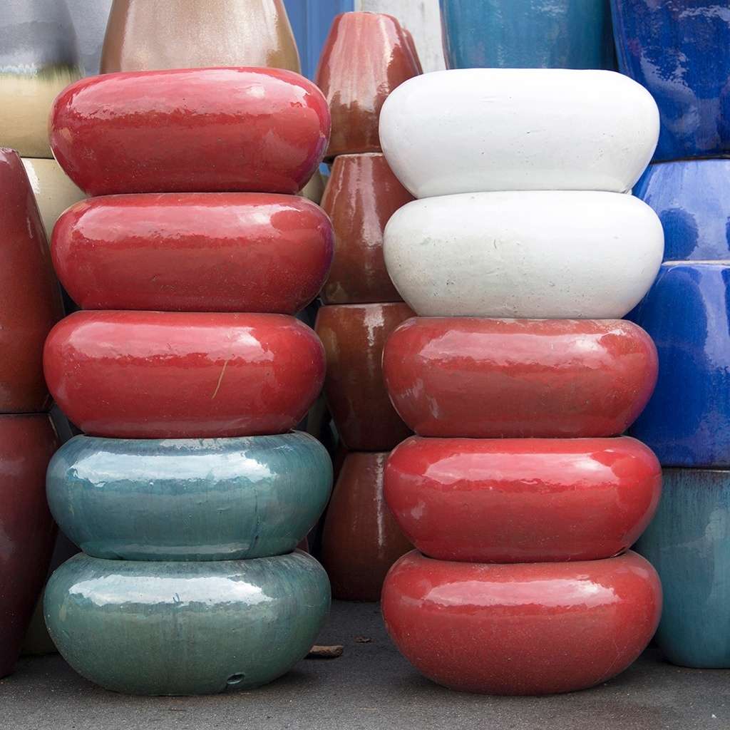 Bulbous low bowl planters in red, opal green, and white, featuring rounded shapes and smooth glazed finishes