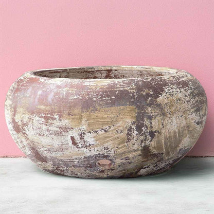 Bulbous low bowl planter with a distressed finish in reddish brown and off-white tones