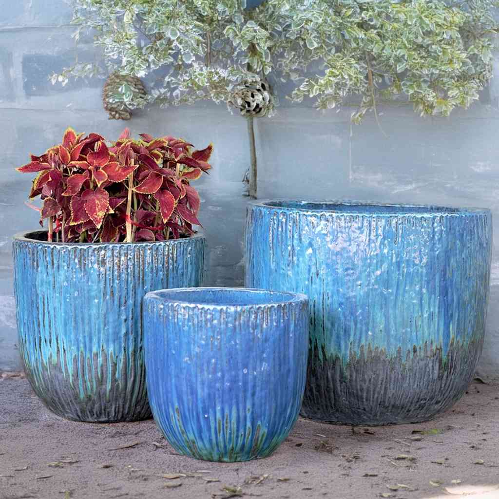Blue ceramic planters with a bark-like textured surface and a greenish-brown base