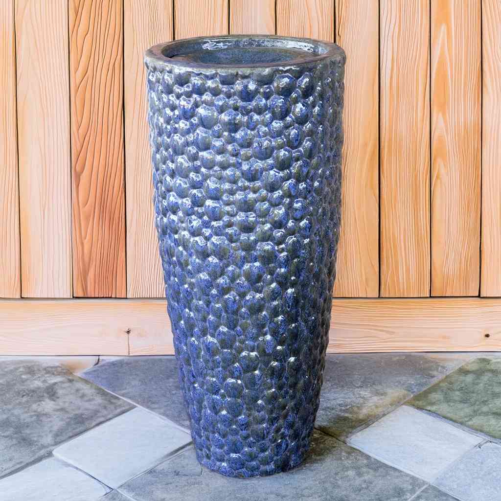 Tall ceramic planter with a pebbled texture and a glossy blue glaze