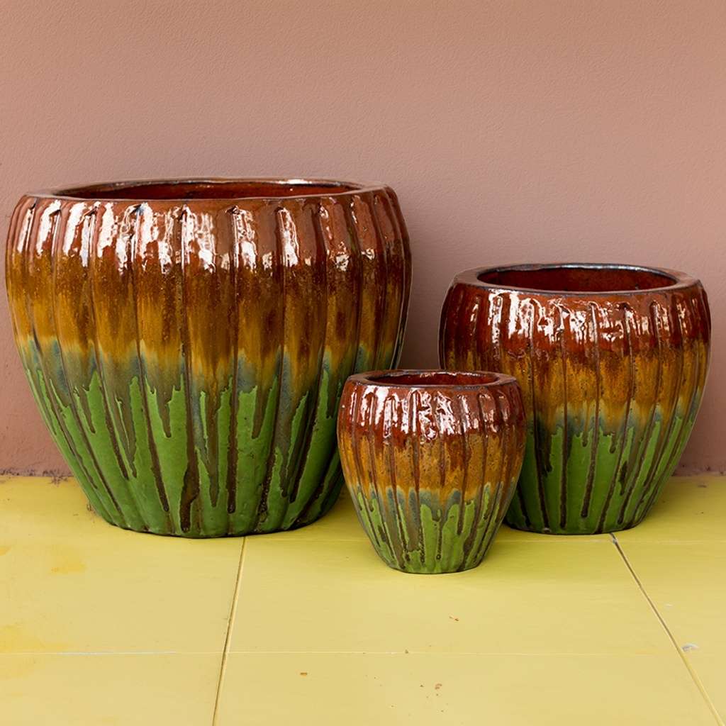 Round ribbed ceramic planters with a multi-toned iridescent glaze blending brown, green, and yellow hues