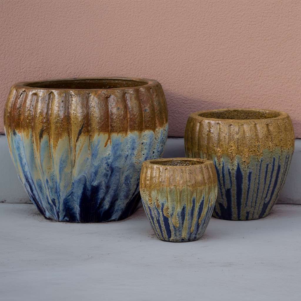Round ribbed ceramic planters with a multi-toned iridescent glaze in blues, brown, and gold