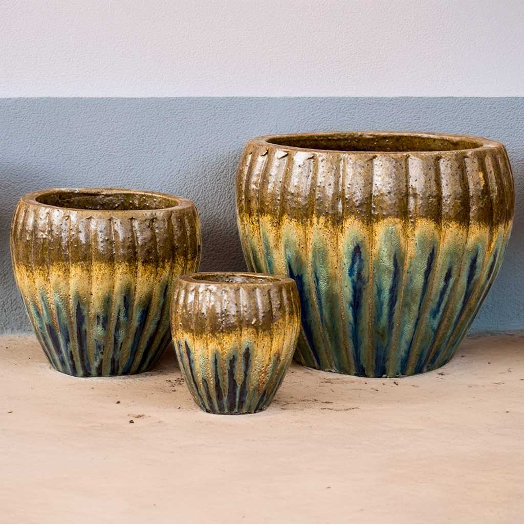 Round ribbed ceramic planters with a multi-toned iridescent glaze blending brown, bronze, blue, and green hues