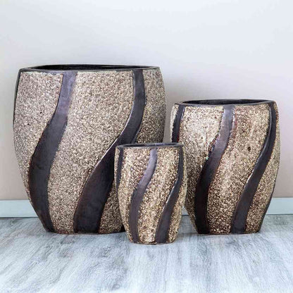 Modern oval ceramic pot with a textured white stone finish and dark brown swirling accents